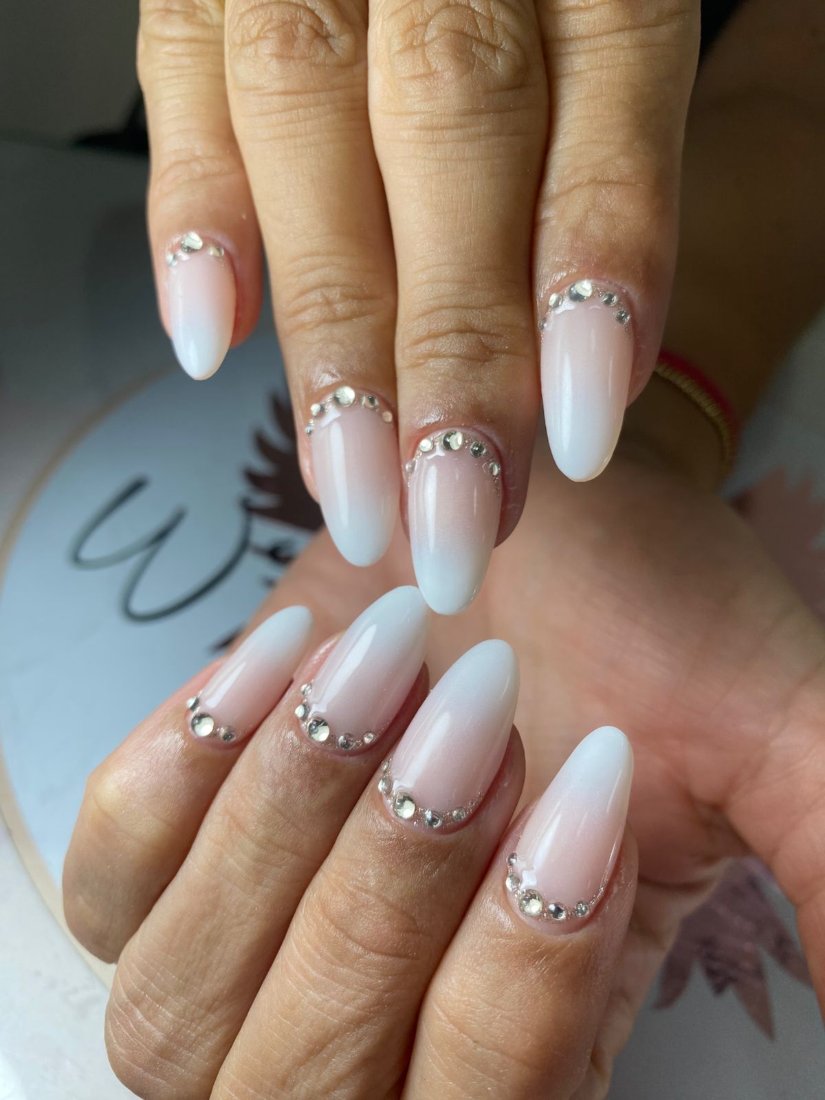 Gallery montage of various manicures including deep red, nude with minimalist dots, shimmering gold, soft grey, and classic bright red finishes.